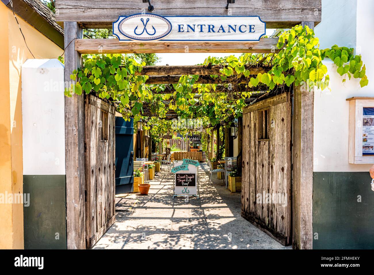 St. Augustine, USA - May 10, 2018: Shops stores restaurants alley in downtown Florida city with entrance to courtyard path architecture in famous colo Stock Photo