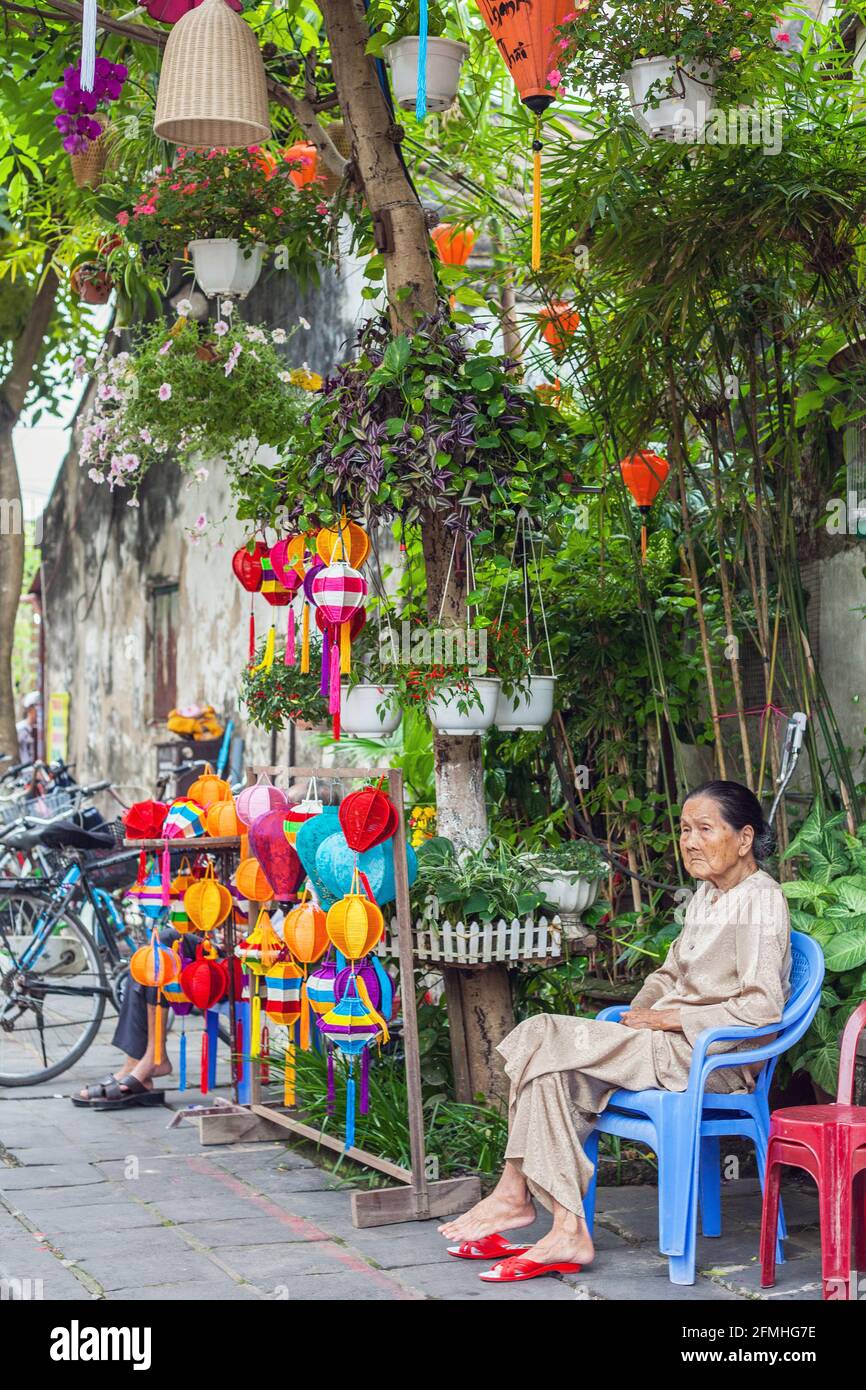 Elderly Vietnamese lady sits selling colourful lanterns in the old town, Hoi An, Vietnam Stock Photo