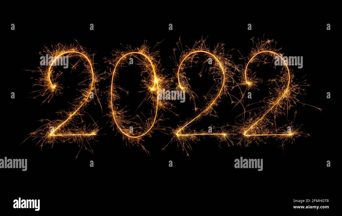 Happy New Year 2022 written with bengal fire, sparkler fireworks candle isolated on a black background. New Year dark background. Stock Photo
