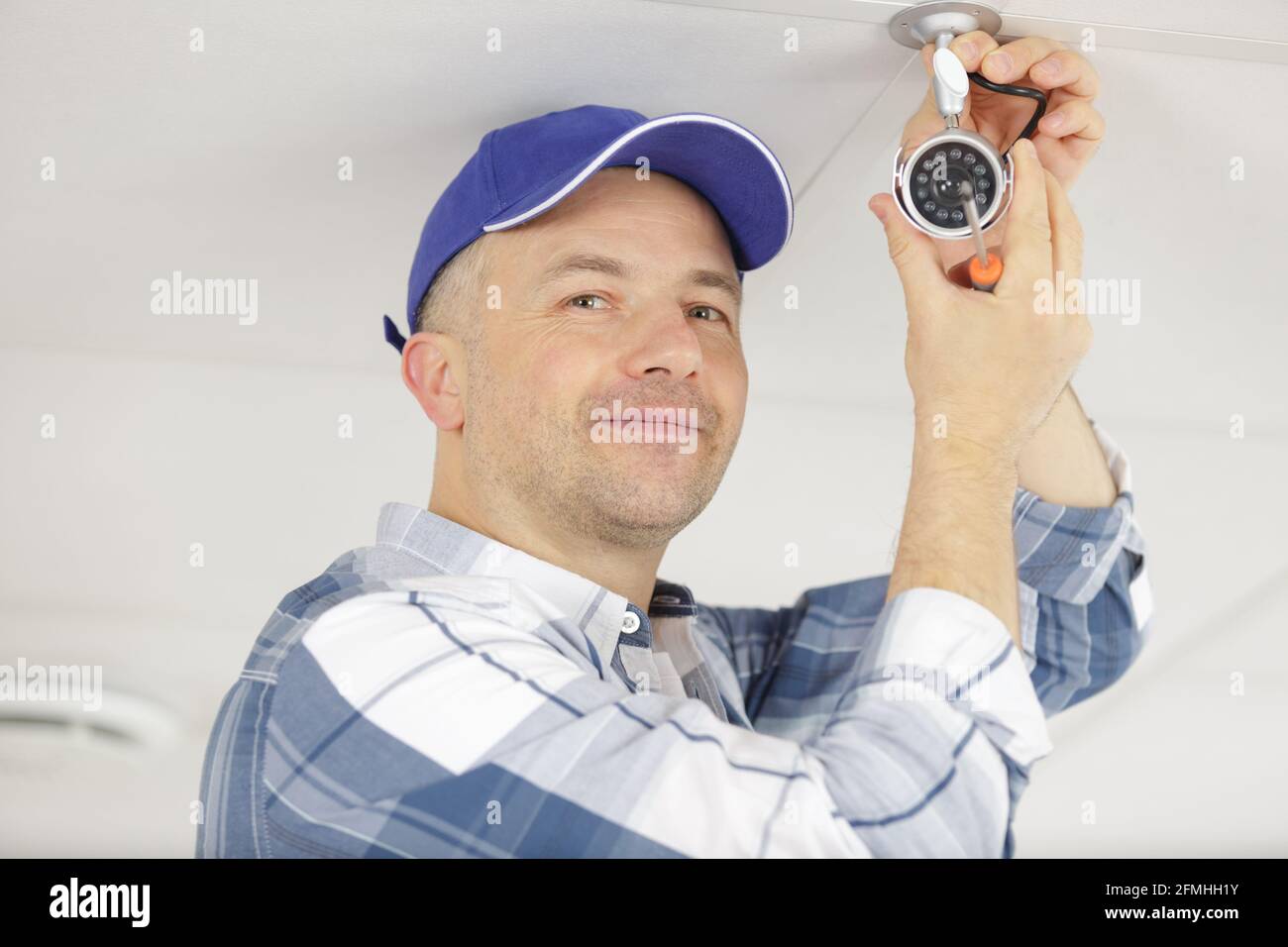contractor installing surveillance cctv cameras in office Stock Photo