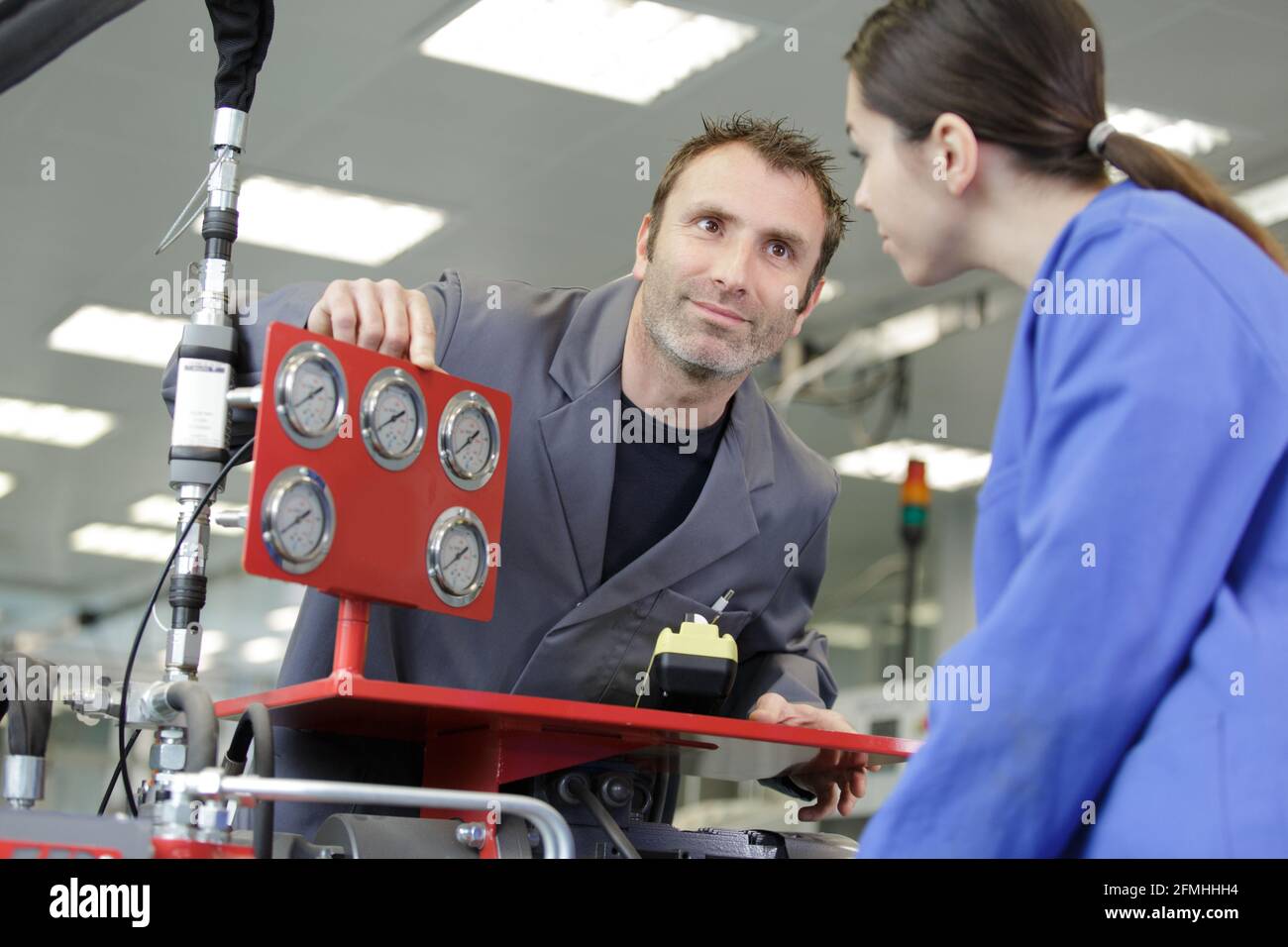 portrait of apprentice working with engineer on cnc machine Stock Photo