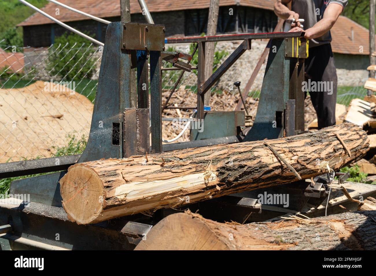 Putting log on the moving platform at sawmill ready to cut into planks sawmill industry wood