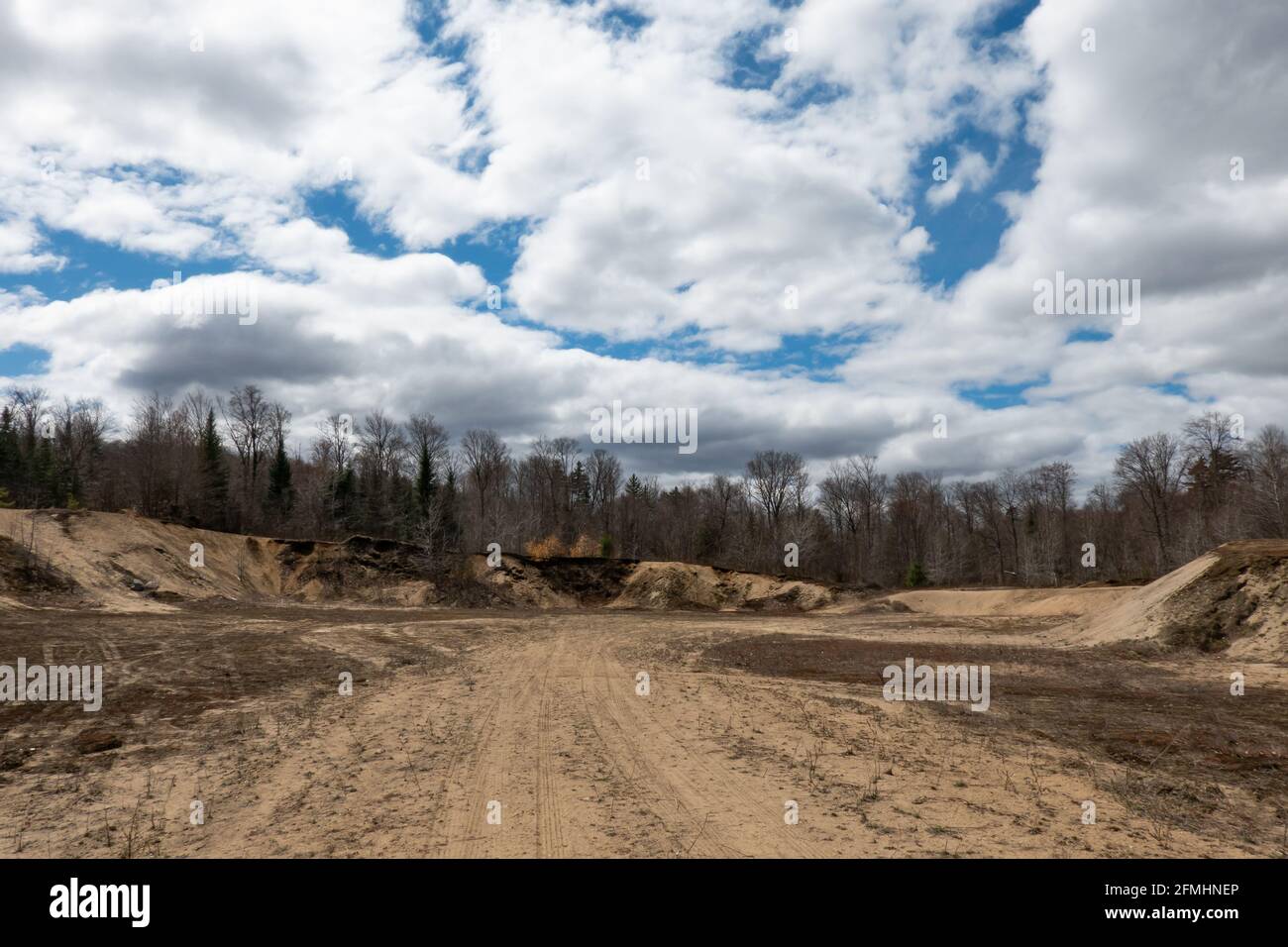 A large sand and gravel pit in the Adirondack Mountains, NY USA with a blue sky and clouds background. Stock Photo