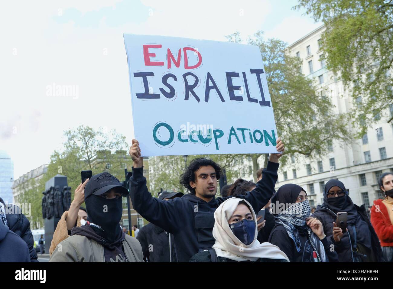 A protester holds up a placard 'End Israeli Occupation' at a demonstration against forced evictions of Palestinian families in Jerusalem Stock Photo
