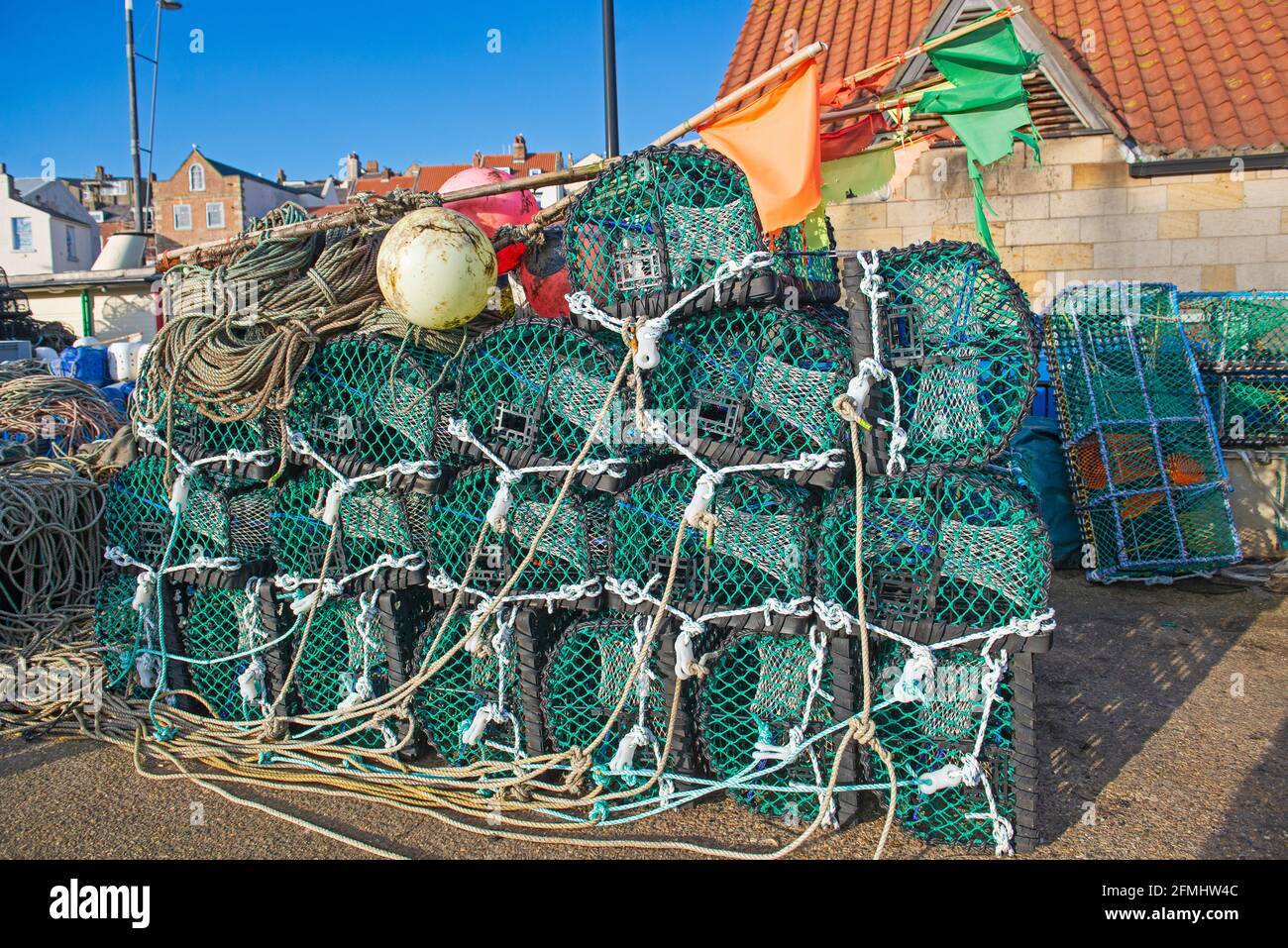 Lobster pots stacked up in a pile on a harbor quayside of fishing port Stock Photo