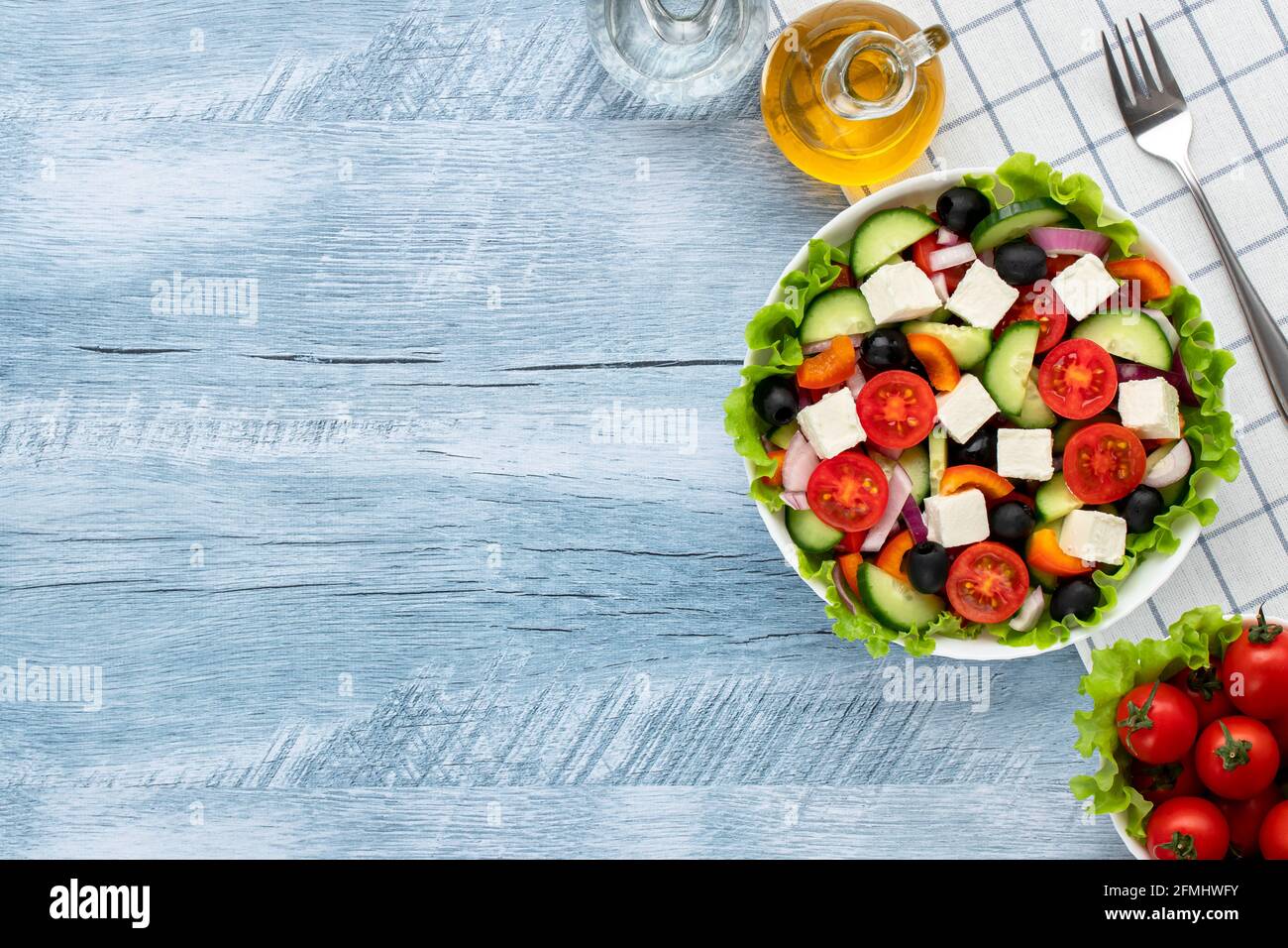 Greek salad or horiatiki salad made with pieces of tomatoes, cucumbers, onion, feta cheese, bell pepper slices, olives and dressed with olive oil. Hea Stock Photo