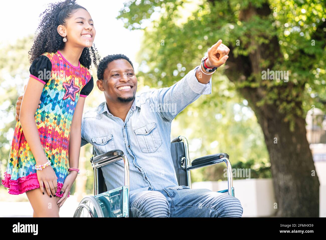Man in a wheelchair enjoying a walk with his daughter Stock Photo - Alamy