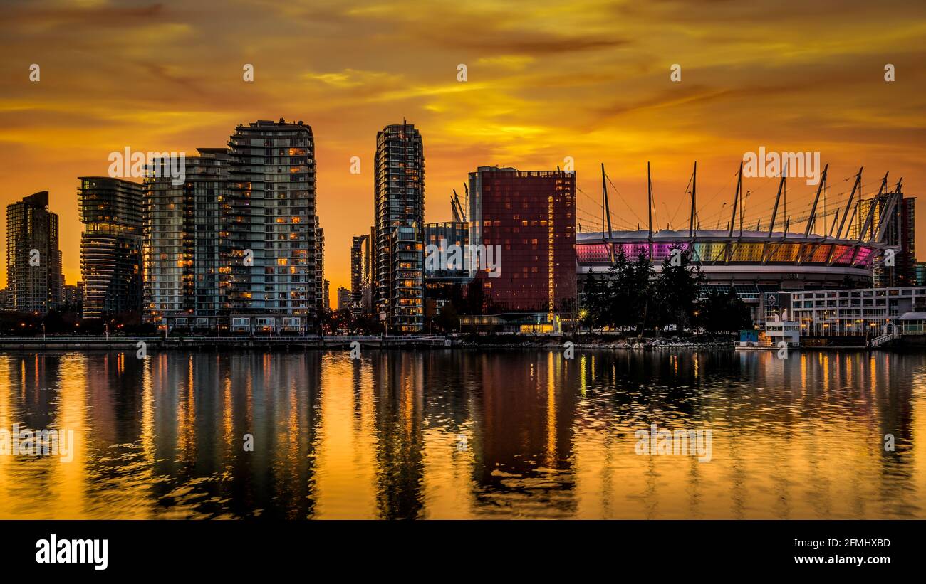 Orange Sky from the Sun setting over BC Place and the Vancouver Yale Town Skyline at the North Shore of False Creek, British Columbia, Canada Stock Photo