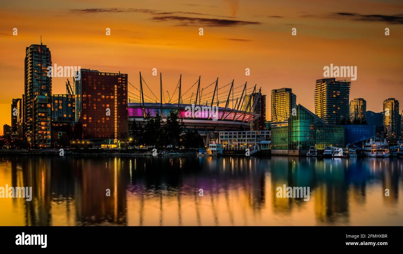 Orange Sky from the Sun setting over BC Place and the Vancouver Yale Town Skyline at the North Shore of False Creek, British Columbia, Canada Stock Photo