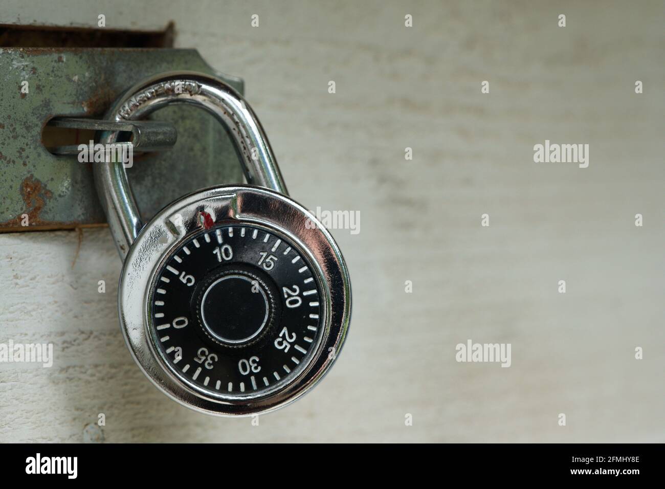Generic combination rotary lock on wooden gate with metal latch. Words