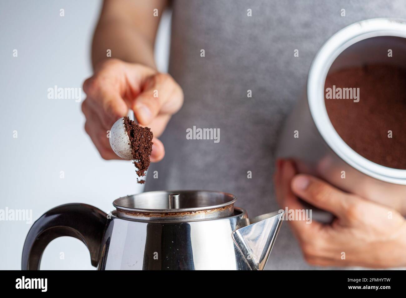 jar using a plastic measuring spoon 