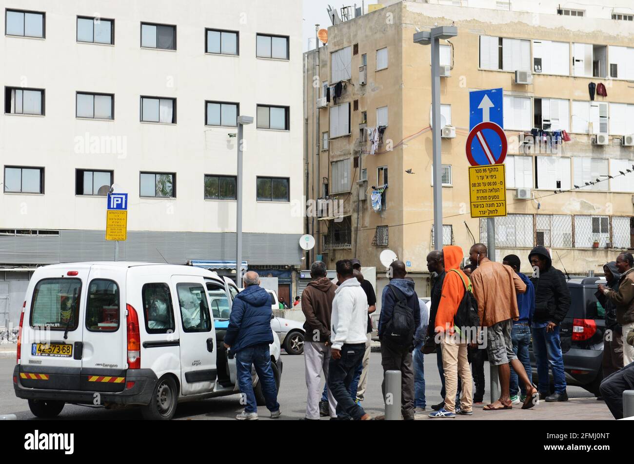 Illegal African migrants and refugees waiting to be picked up for work ( mostly construction ) in Southern Tel-Aviv. Stock Photo