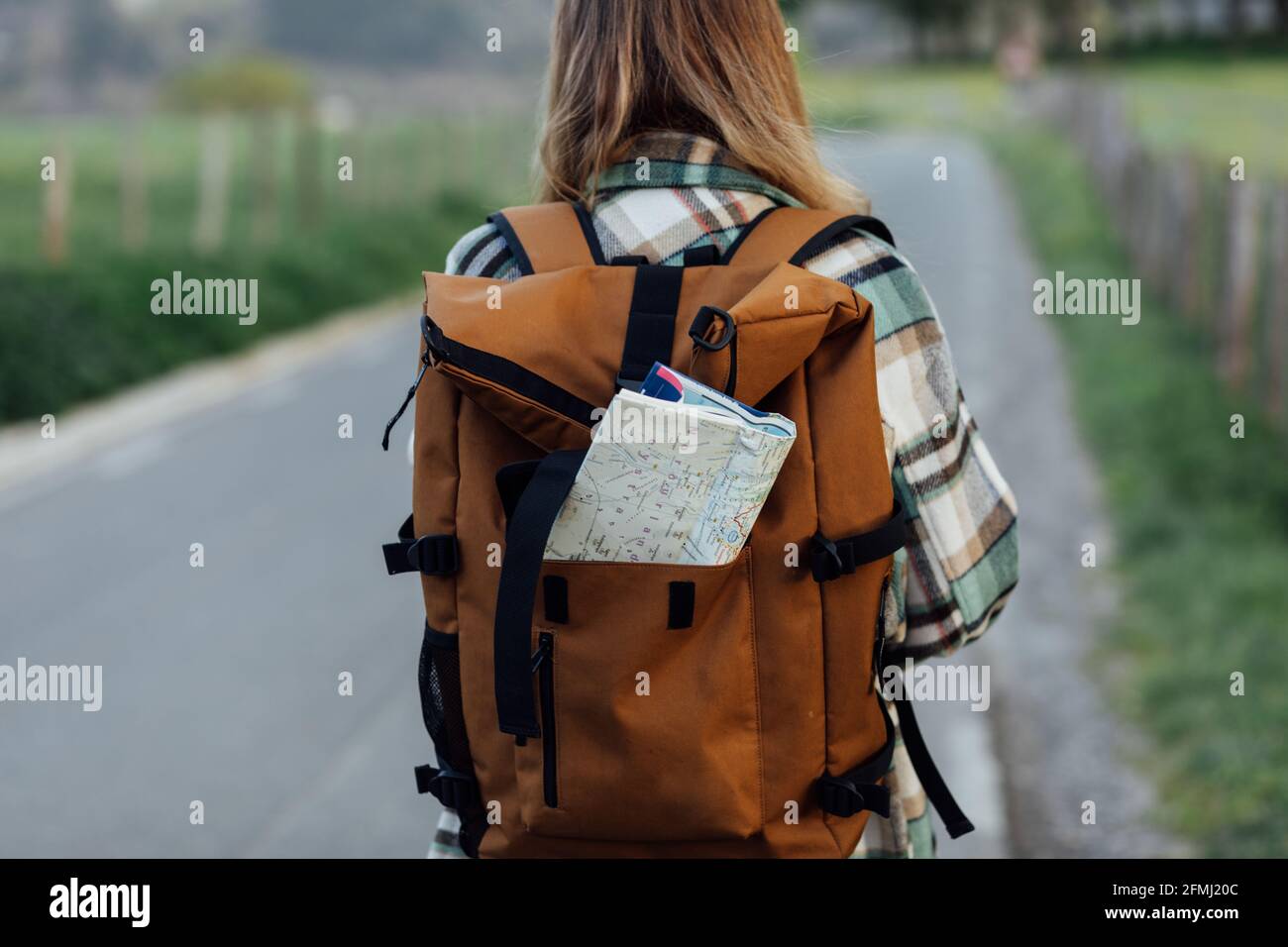 Back view of crop anonymous female hiker with route map in backpack on ...
