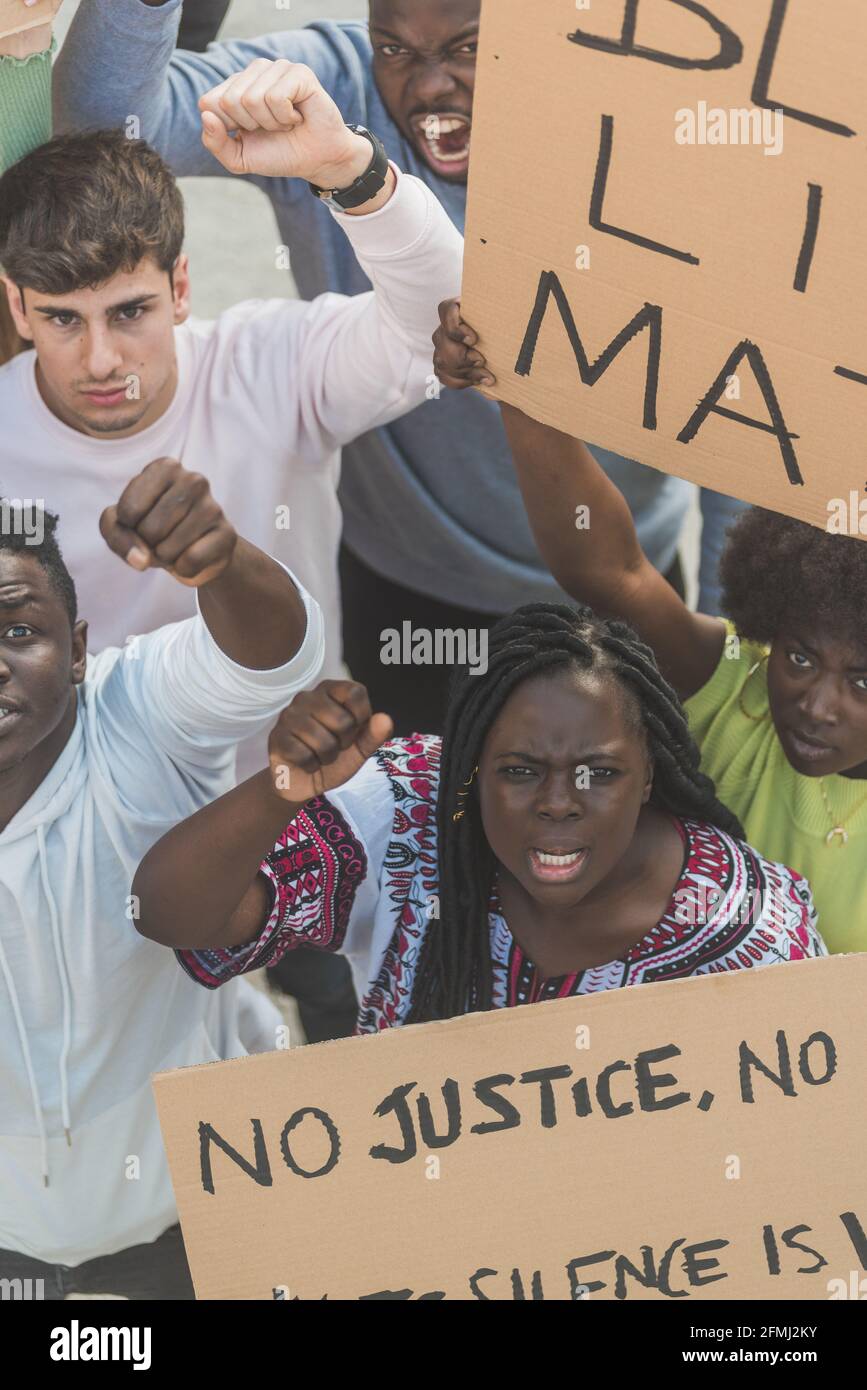 From above of crowd of multiracial people with posters screaming during Black Lives Matter demonstration in city and looking at camera Stock Photo