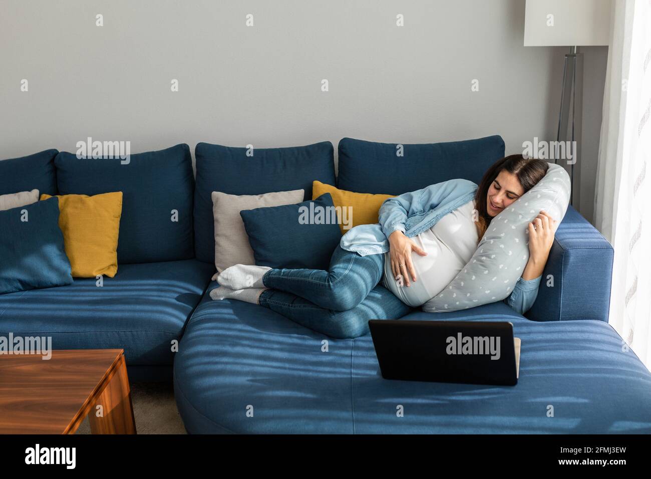 Side view of anonymous flexible female in sportswear standing on head with raised legs while practicing yoga in house Stock Photo