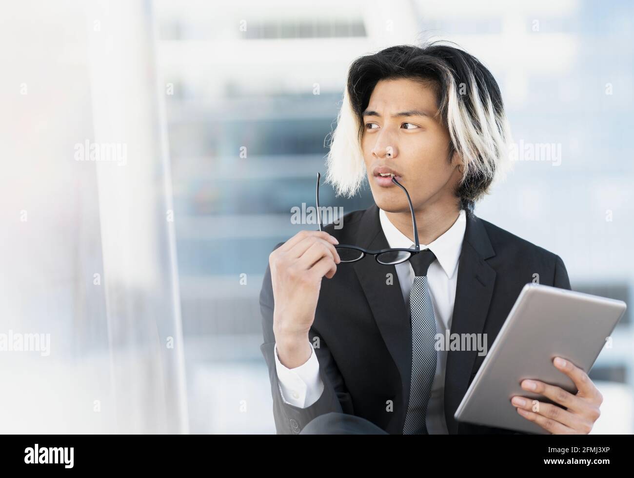 Young well dressed ethnic thoughtful male executive browsing internet ...