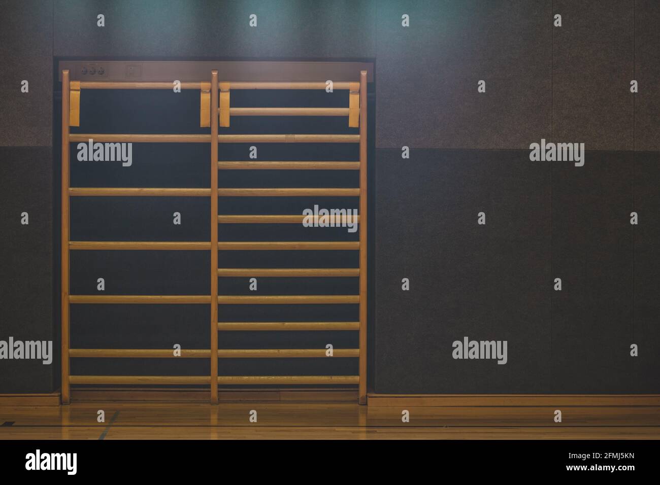 Frontal view of a wooden fitness ladder or bars, mounted on a wall in