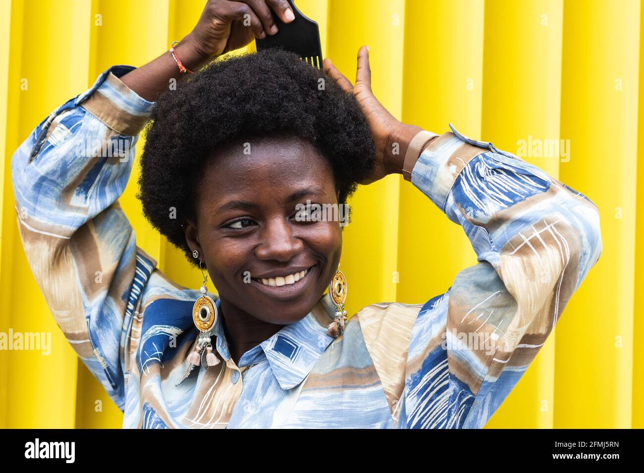 Full body side view of active young male in checkered shirt and jeans performing trick on
