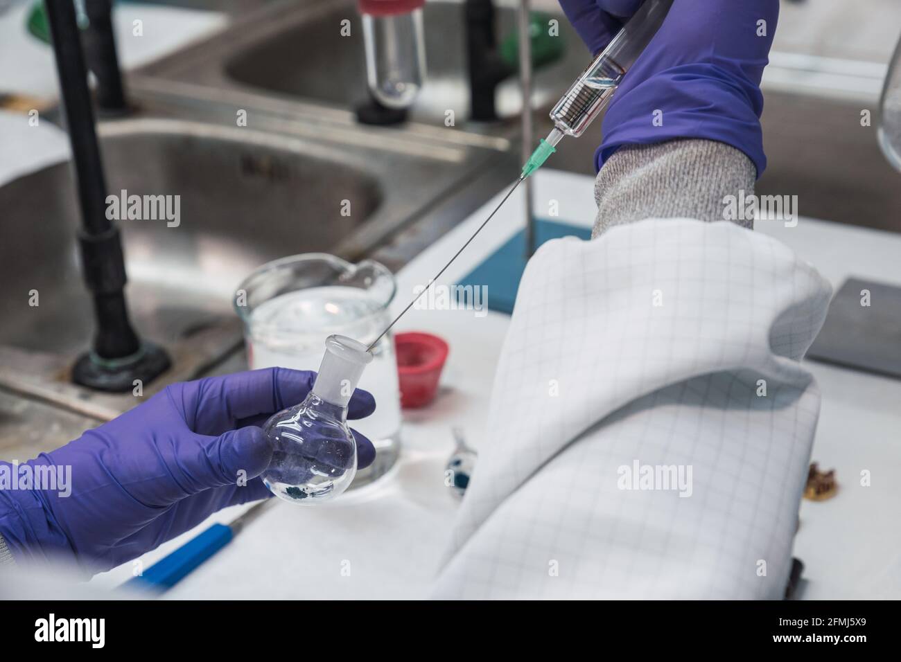 Chemical Robe Crop unrecognizable scientist in white robe and gloves conducting ...