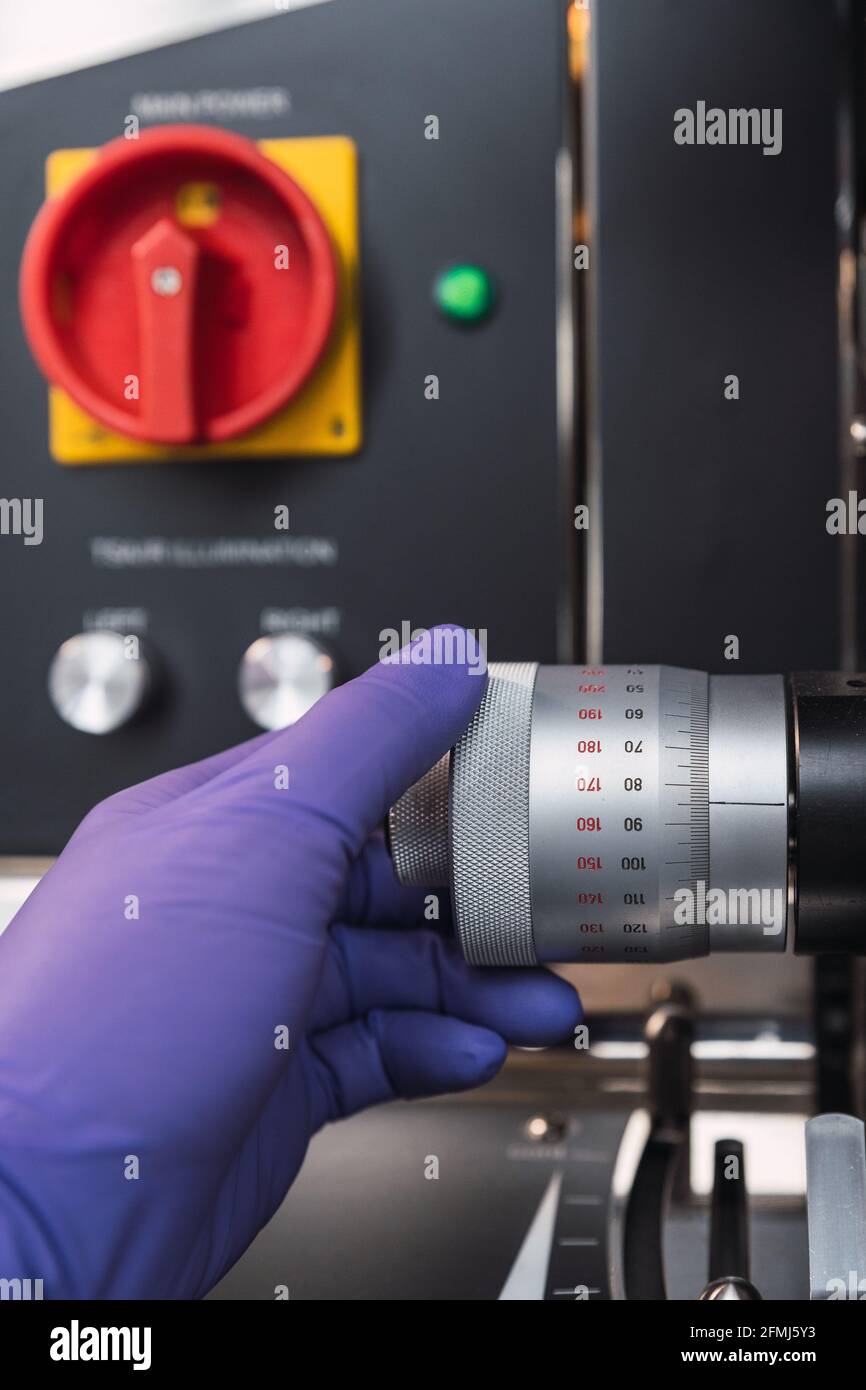 Lab Tech Face Less Crop faceless laboratory specialist in latex gloves adjusting powerful ...