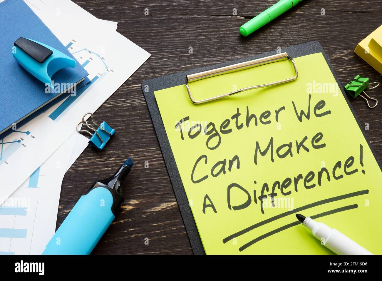 Together we can make a difference slogan on the clipboard. Stock Photo