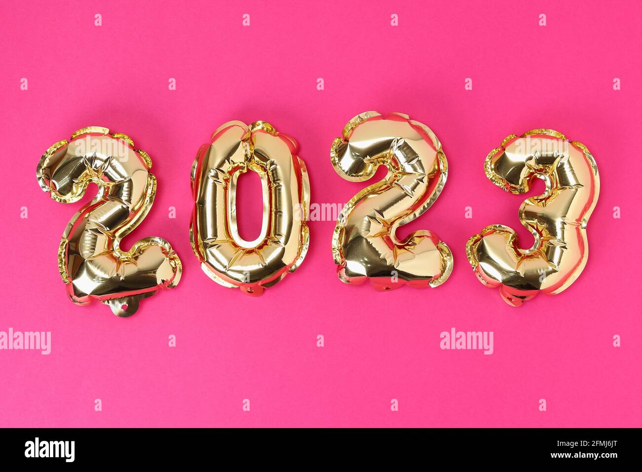 New Year 2023. Foil balloons numbers 2023 on a pink background. New Year Christmas. Stock Photo
