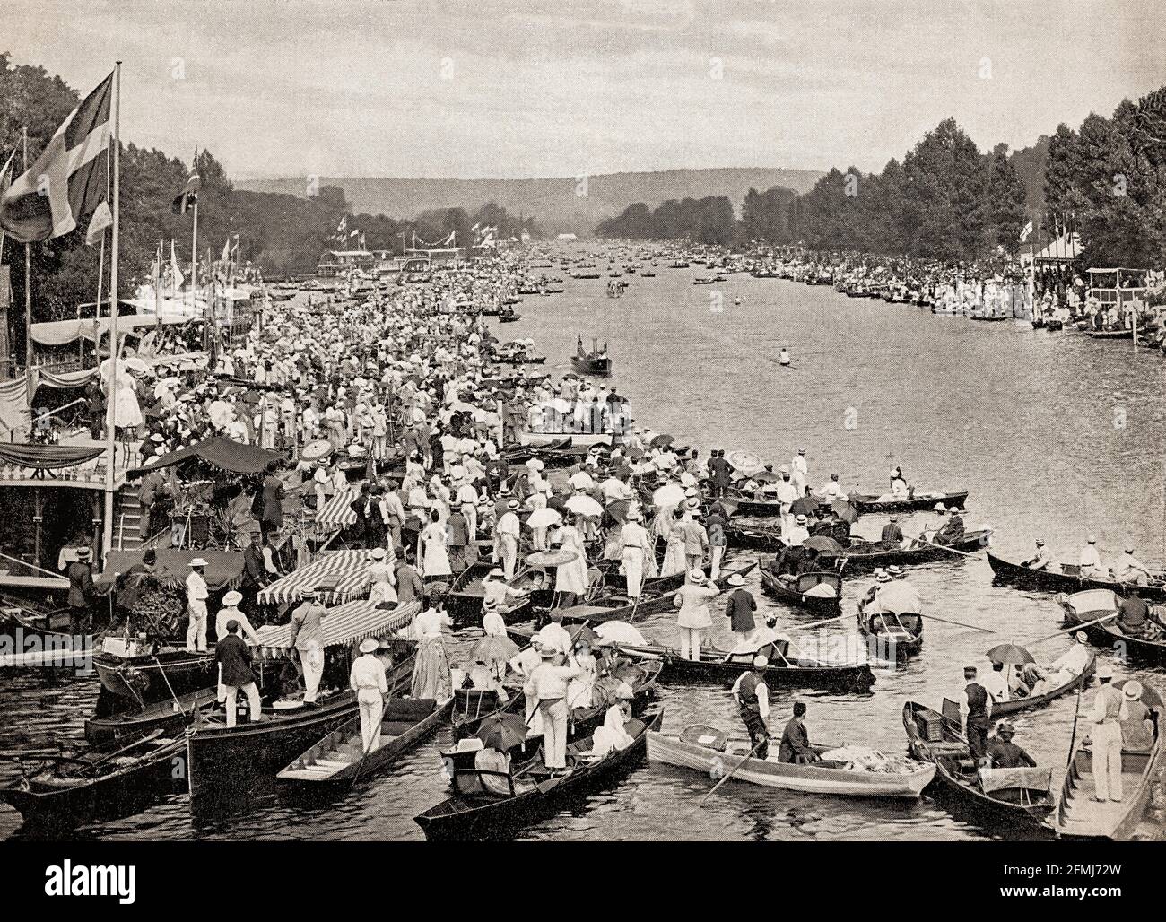 A late 19th Century view of many spectators lining the sides of the River Thames during Henley Royal Regatta (or Henley Regatta, its original name pre-dating Royal patronage), a rowing event held annually on the river at  the town of Henley-on-Thames, Oxfordshire, England. It was established on 26 March 1839, and became 'Royal' in 1851, when Prince Albert became patron of the regatta. Stock Photo