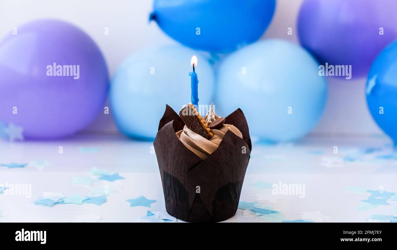 Sweet tasty chocolate cupcake with candle on blue festive background. Happy  Birthday party concept. Delicious birthday cake Stock Photo - Alamy