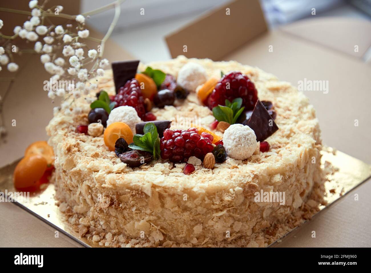 Birthday cake decorated with fruit, pomegranate seeds, chocolae and grapes in he box. Top view. High quality photo Stock Photo