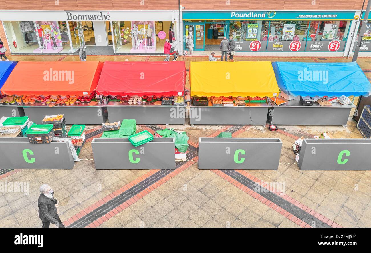 Covered market stalls in front of Bonmarche and Poundland shops at the shopping centre of Corby, Northamptonshire, England. Stock Photo