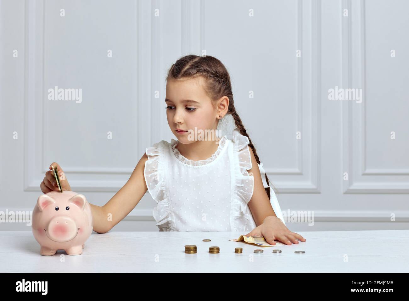 Little child girl with piggy bank at home Stock Photo - Alamy