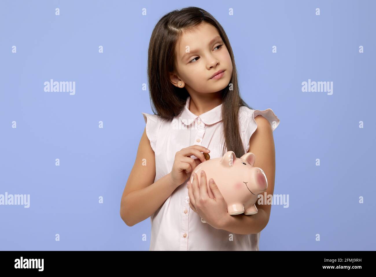 smiling child girl holding pink piggy bank Stock Photo - Alamy