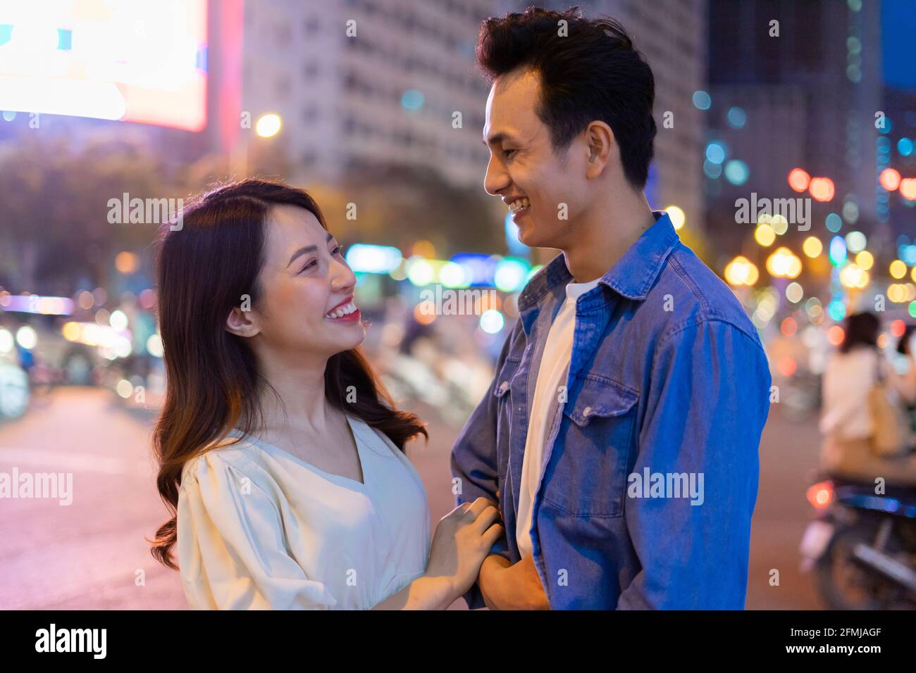 Young Asian couple walking on the street at night Stock Photo - Alamy