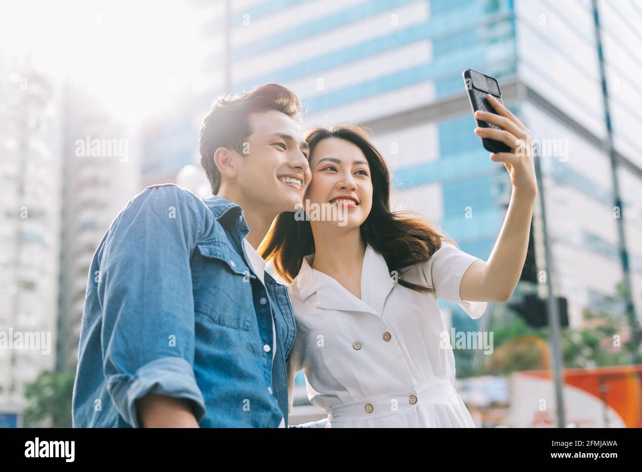 Young Asian couple taking selfie together on the street Stock Photo