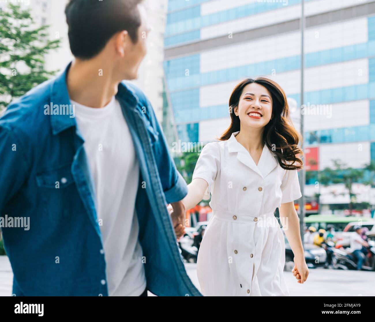 Young Asian couple walking on the street Stock Photo - Alamy