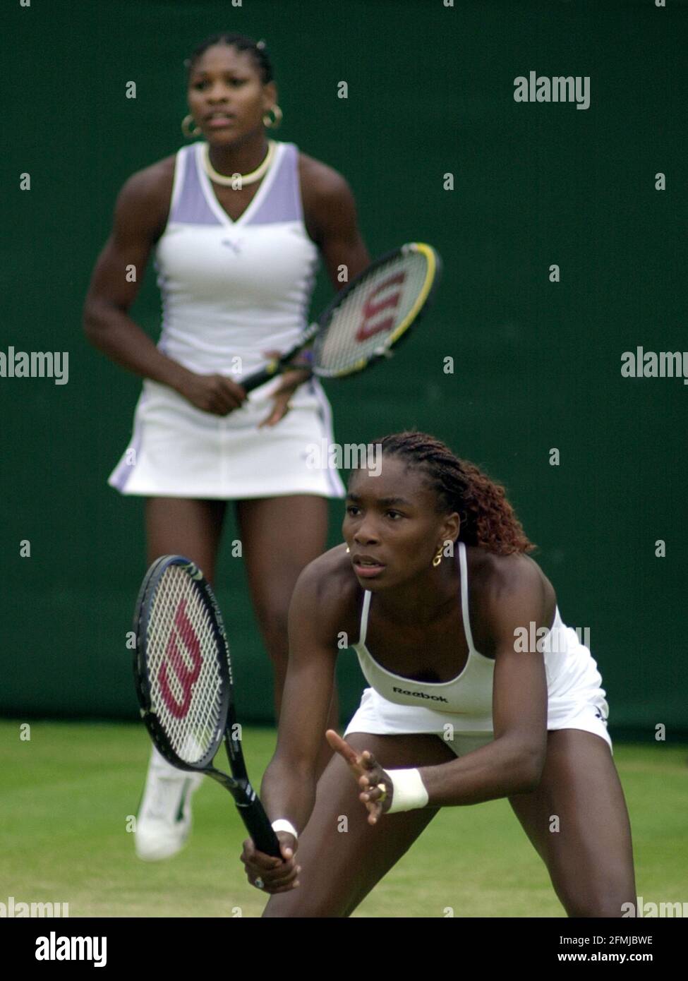 sisters Serena Williams and  Venus Williams July 2000 playing doubles at Wimbledon the day before they meet in the Singles semi finals Stock Photo