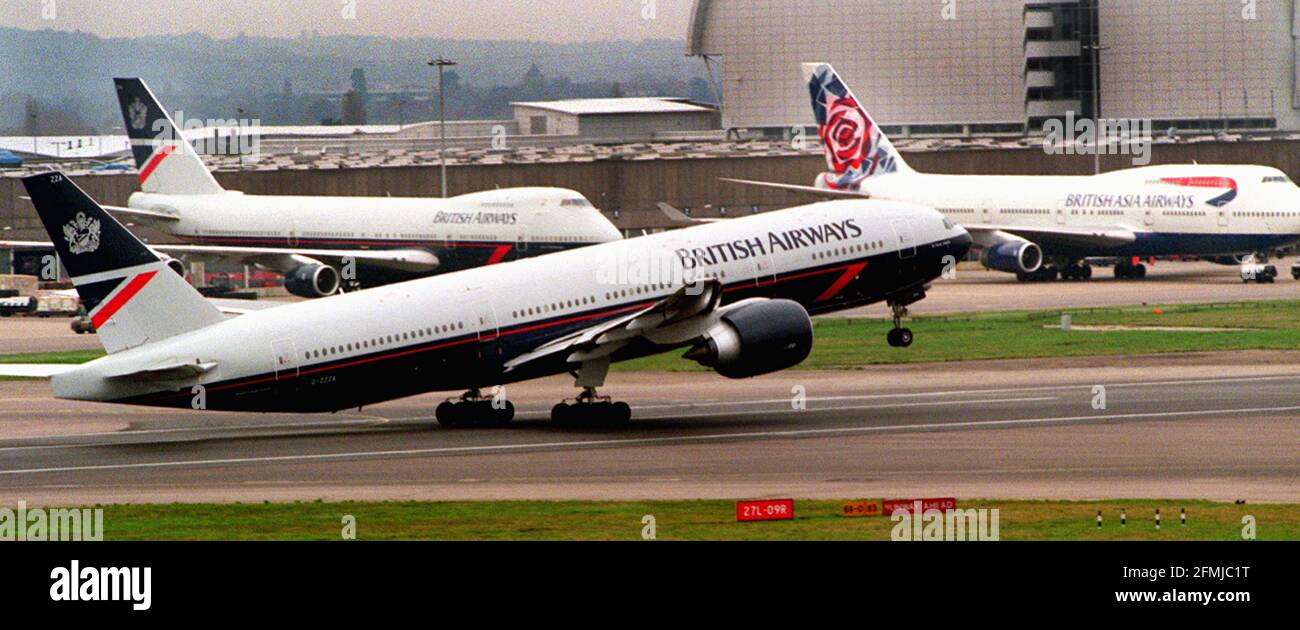 A British Airways Boeing 777 takes off at Heathrow Nov 1999 past BA Boing 747 jumbo jets waiting at London Airport Stock Photo