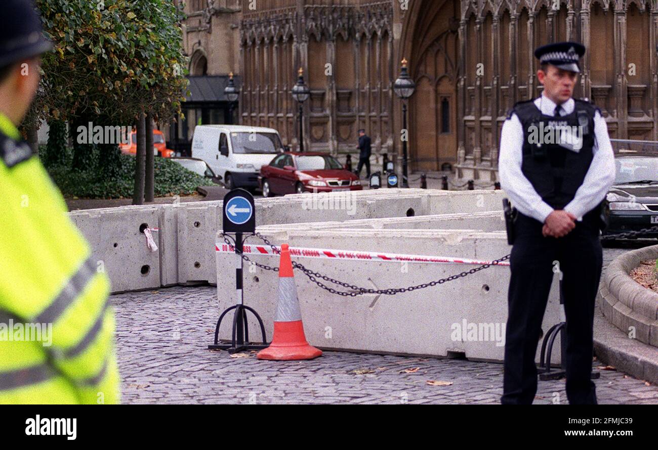 EXTRA SECURITY AT THE HOUSE OF COMMONS. CONCRETE BLOCKS AT THE VEHICLE ENTRANCE TO THE COMMONS ADD EXTRA SECURITY. ALSO, POLICEMAN ON THE RIGHT HAS A GUN IN A HOLSTER ON HIS WAIST. 4 October 2001     PIC;JOHN VOOS Stock Photo