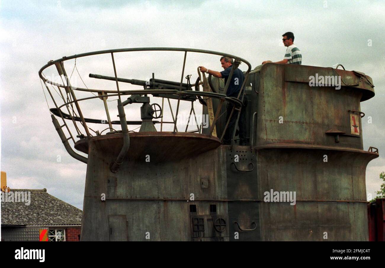 A REPLICA SUBMARINE AUGUST 2000 WAS TRANSPORTED IN SECTIONS FROM PINEWOOD STUDIOS WHERE IT WAS USED IN A FILM CALLED ENIGMA, TO BLETCHLEY PARK WHERE IT WILL BE USED AS THE BASIS FOR A NEW EXHIBITION TELLING THE TRUE STORY OF HOW ENIGMA SECRETS WERE CAPTURED FROM GERMAN SUBMARINES. PIC SHOWS WORKMEN LOWERING THE CONNING TOWER INTO PLACE FROM THE LOW LOADER Stock Photo