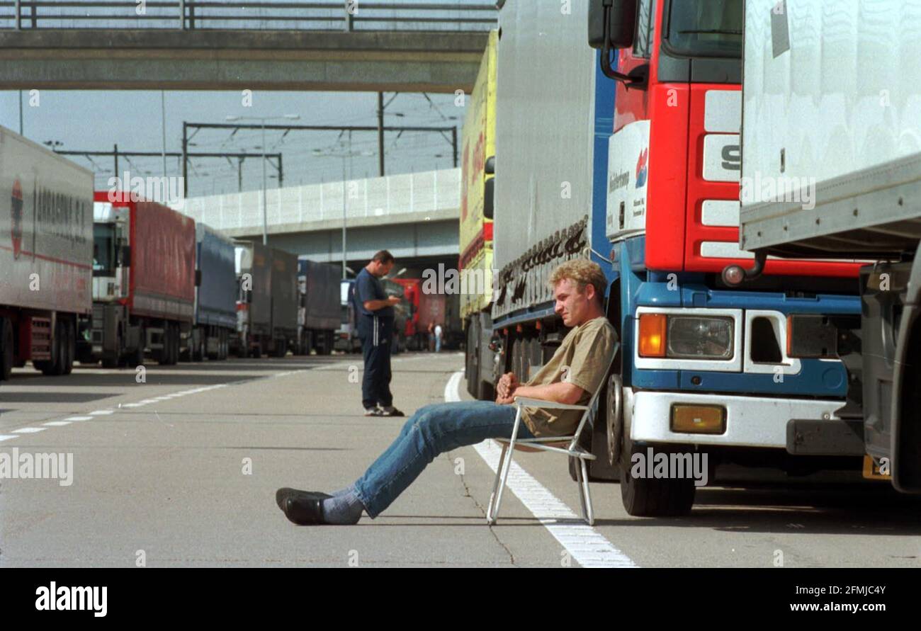 French Fisherman Port Blockade M20 Lorry Park  August 2000 lorries queueing on the M20 on their way to Dover, and on the Channel Tunnel slip road because of french fishermen blockading the french channel ports man in chair is dutch lorry driver Alex Mulder. Stock Photo