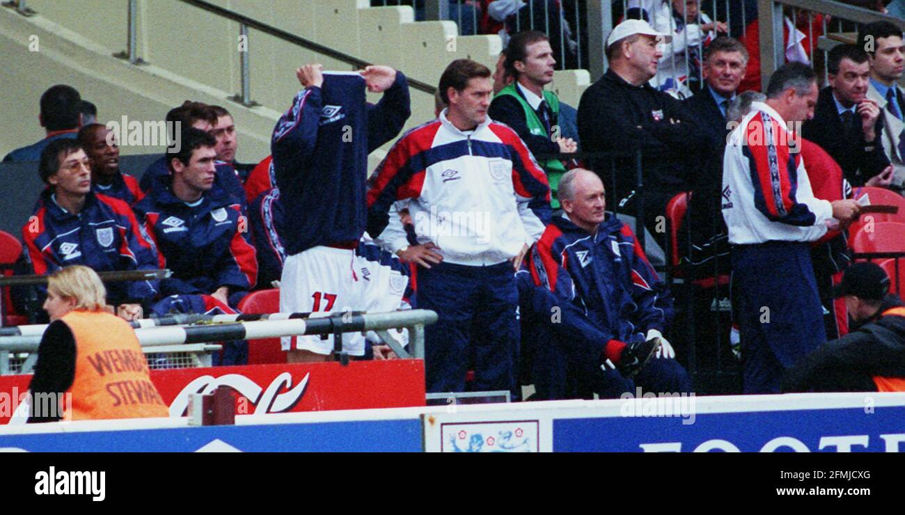 England's Teddy Sheringham in England v Bulgaria 1998 about to come on takes his top off as coach Glenn Hoddle and Ray Clemence watch the game Stock Photo