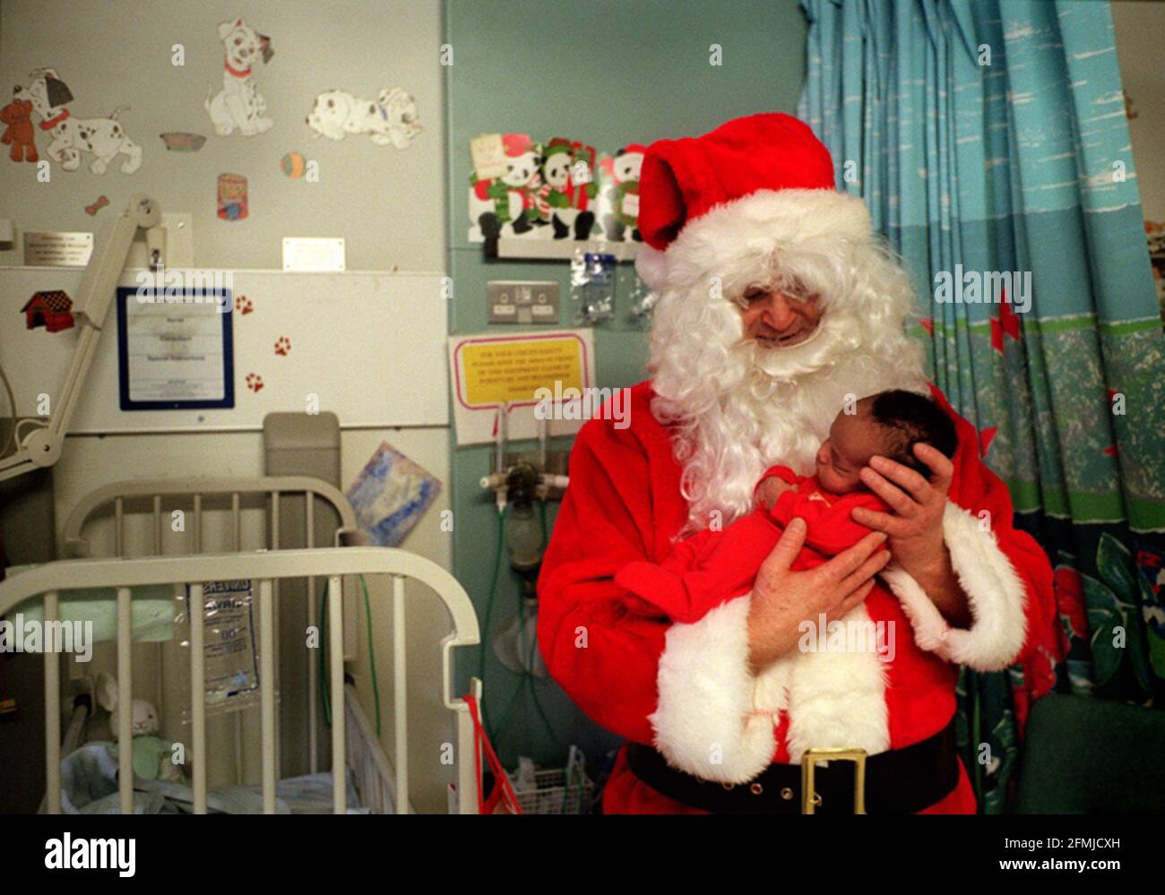 Father Christmas visit to Great Ormond Street Hospital. Pics taken on Parrot Ward (neurosurgical). The hospital had two Father Christmases touring; This one is Peter Jardine, a Senior Staff Nurse from the Cardiac Theatre.  Pic shows 15 day old Kane Williams from Camden in London, who is in for investigations Stock Photo