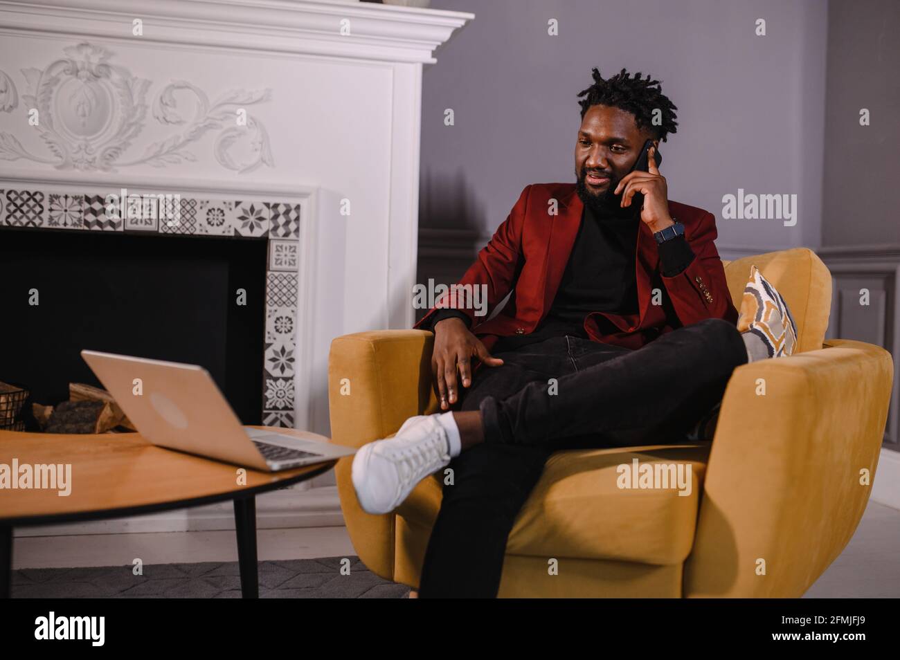 Smiling millennial african american casual man working with apps or communicating online on laptop Stock Photo