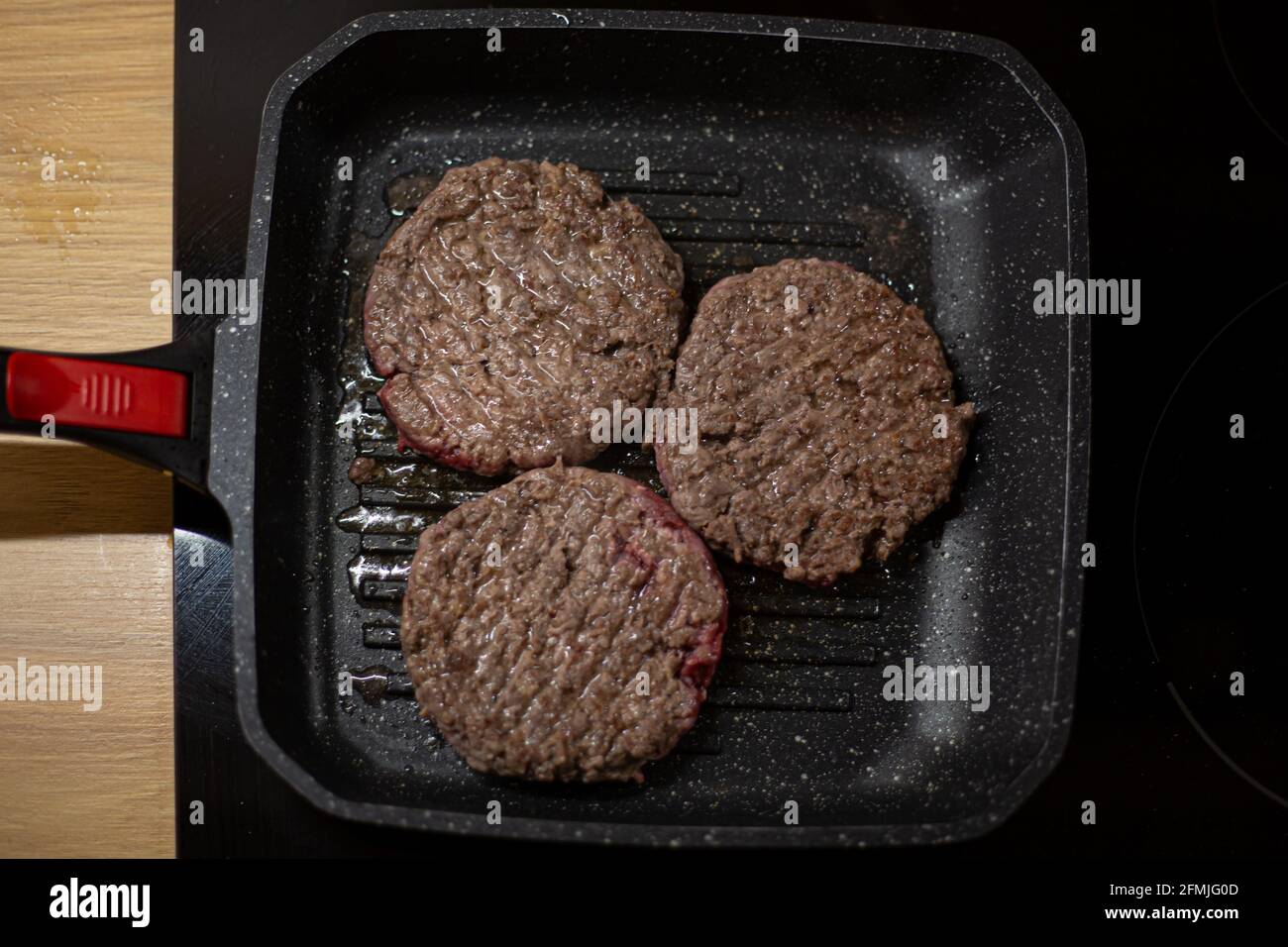 Inzet Geruststellen Onaangeroerd Burger minced beef meat cutlet on a grill pan. Process of cooking self made  burgers at home Stock Photo - Alamy