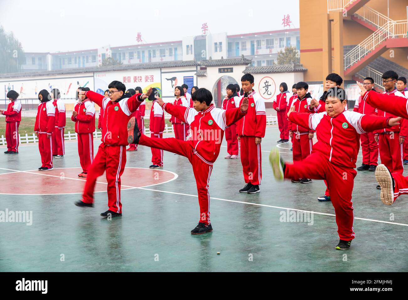 Students at a primary school in Lixian, Hebei, China doing their PE by doing wushu exercise. Stock Photo