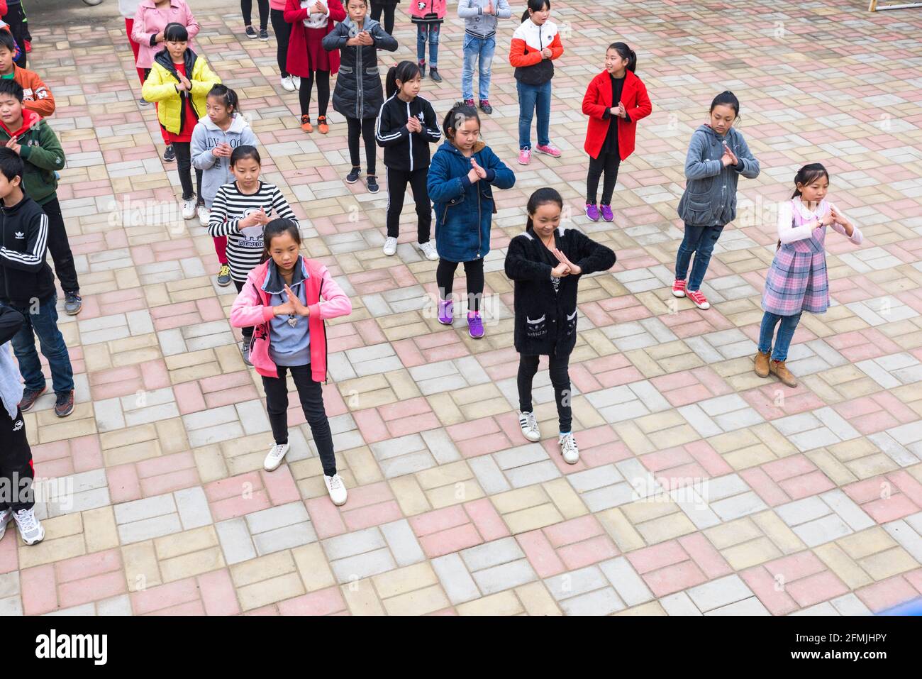 Students at Xilian primary school in Wananzhen, Hebei, China do their daily morning exercise routine to music which is led by a fellow student. Stock Photo