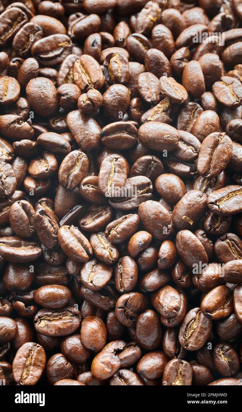 Dark freshly roasted coffee beans background, selective focus. Stock Photo