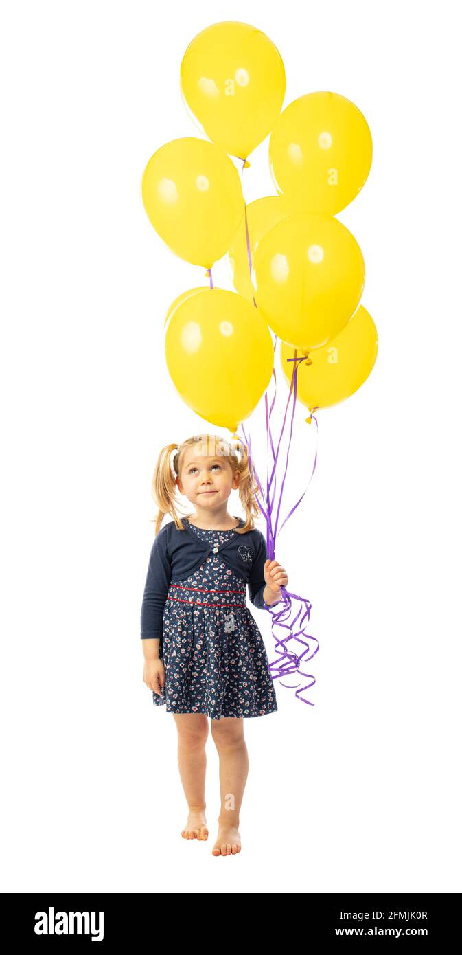 little girl with yellow balloons looks up. isolated on white. Stock Photo