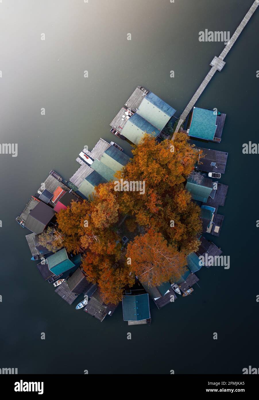 Tata, Hungary - Aerial top down view of a small fishing island at Lake Derito (Derito-to) with autumn leaves and foliage at sunset. The lake can be fo Stock Photo