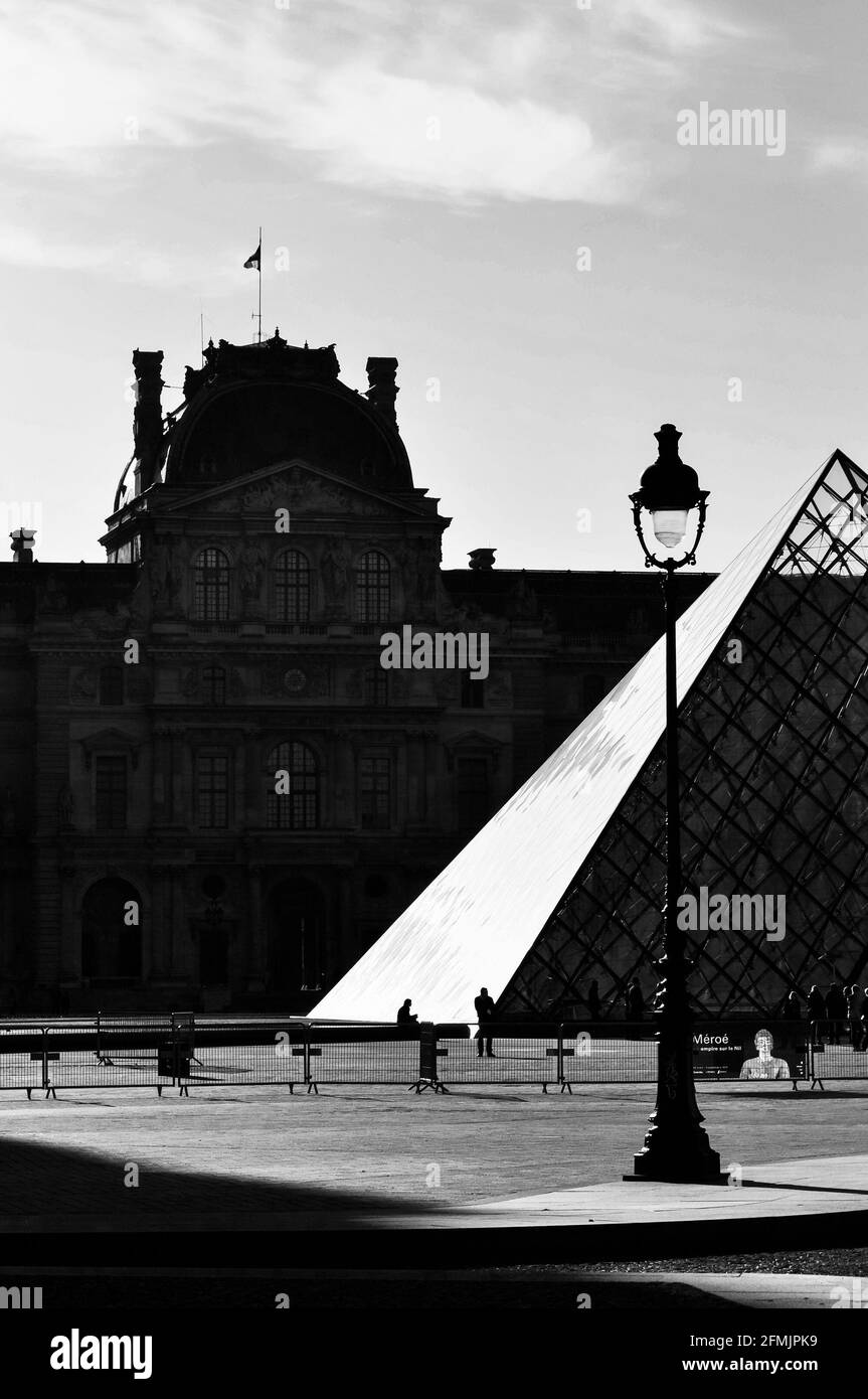 PARIS, FRANCE - CIRCA APRIL 2010: The Louvre Museum and the Pyramid which is the entrance for the museum. Black and white photography. Stock Photo